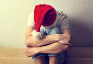 sad man in Santa Hat on the Couch, veteran PTSD and holidays