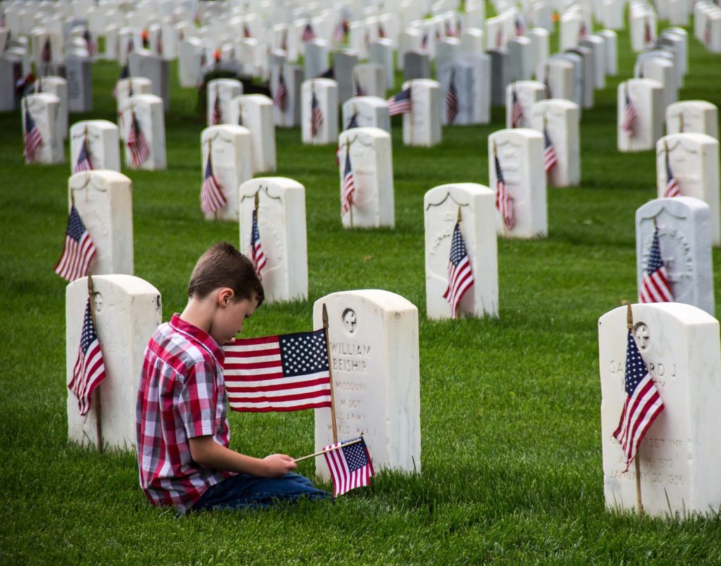 boy visiting Veteran tombstones